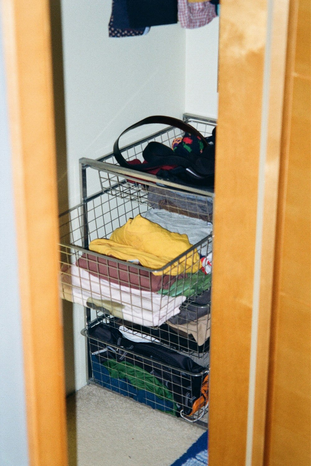 a closet with a basket full of clothes