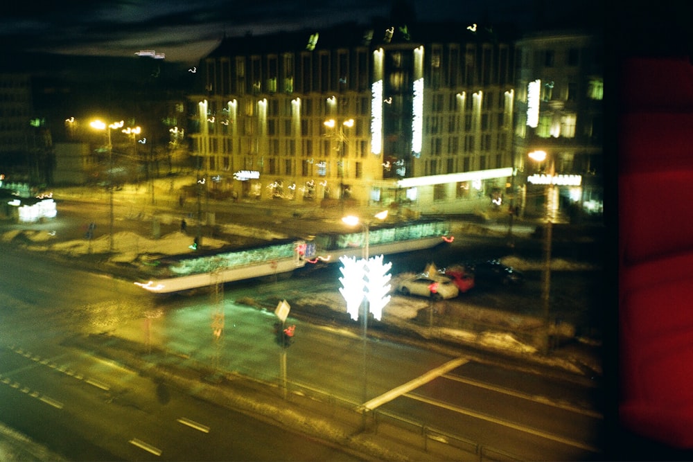 a city street at night with a train on the tracks