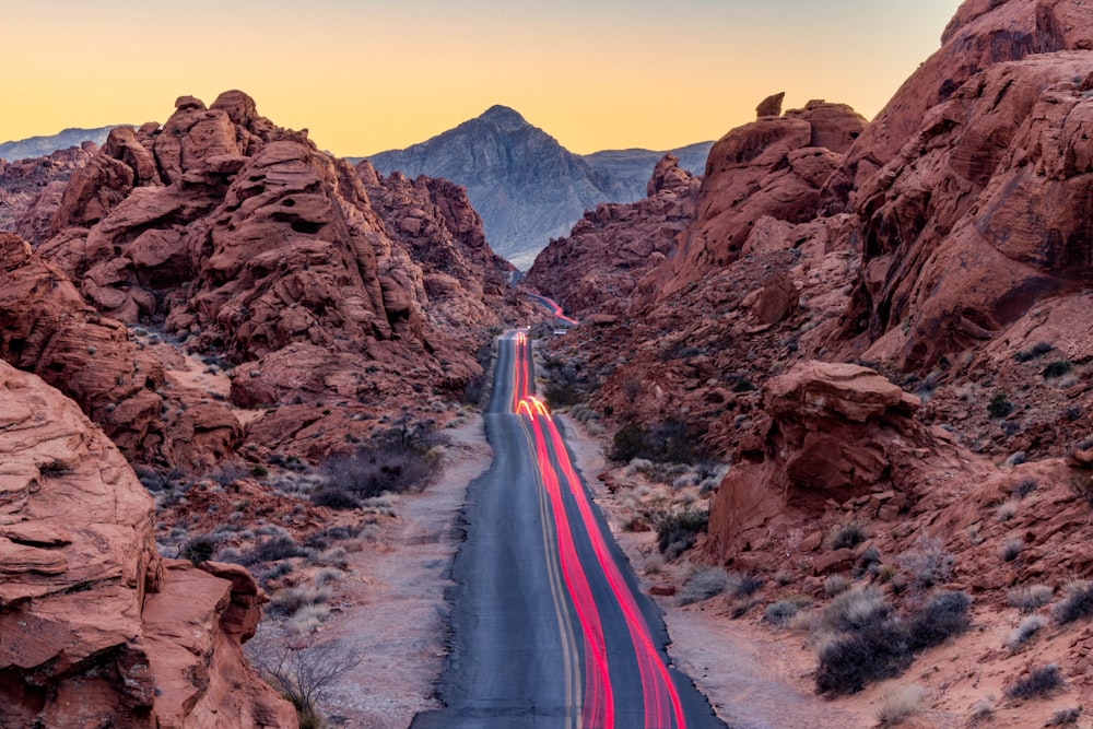 a car driving down a road surrounded by mountains