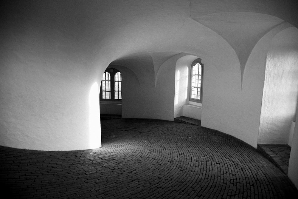 a black and white photo of a room with arched windows