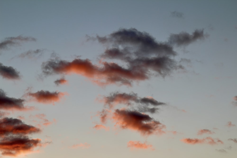 a plane flying in the sky at sunset