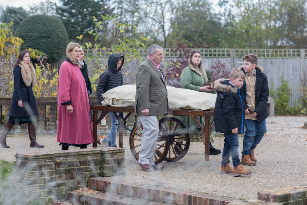 a group of people standing around a wooden cart