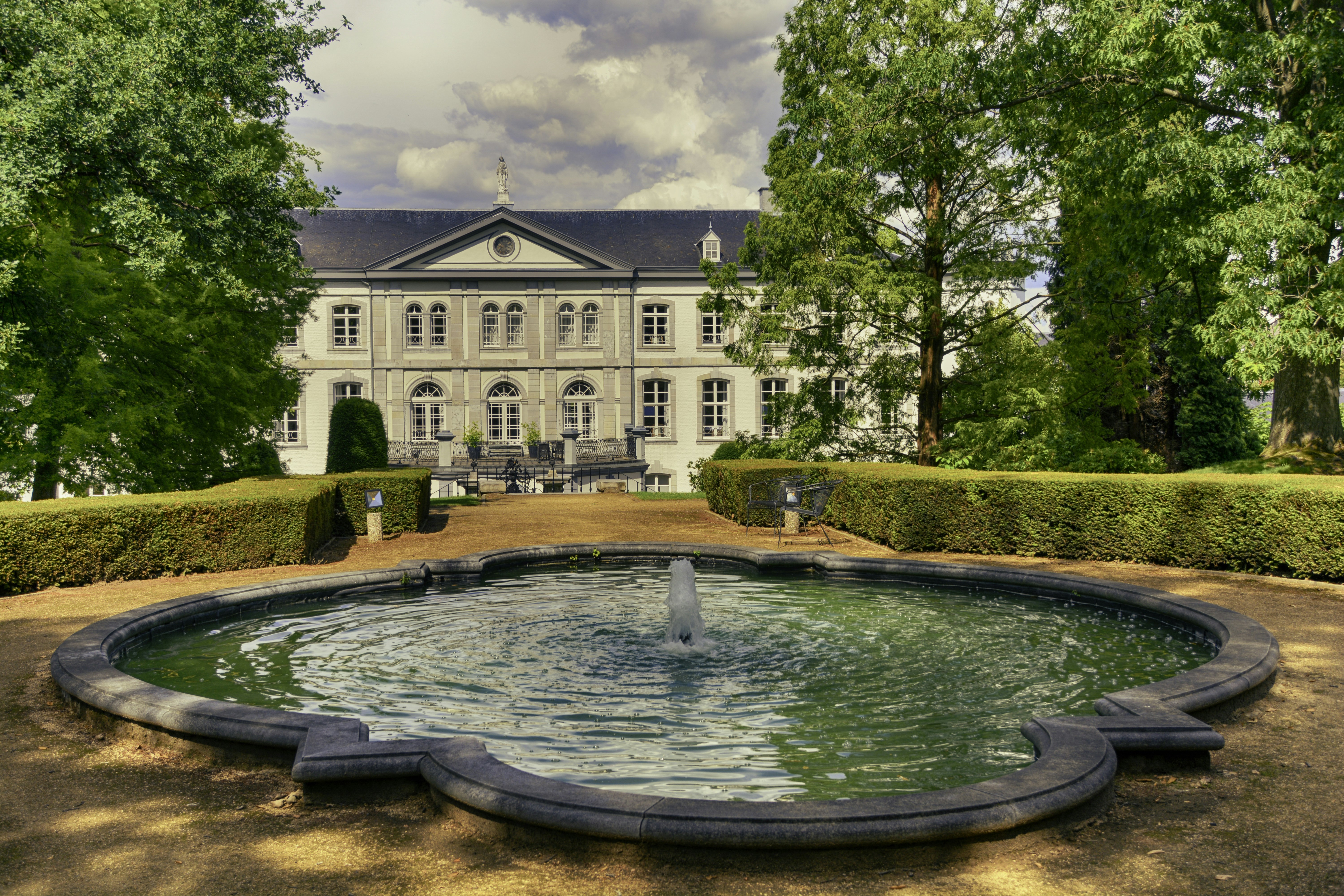 A large house with a fountain in front of it