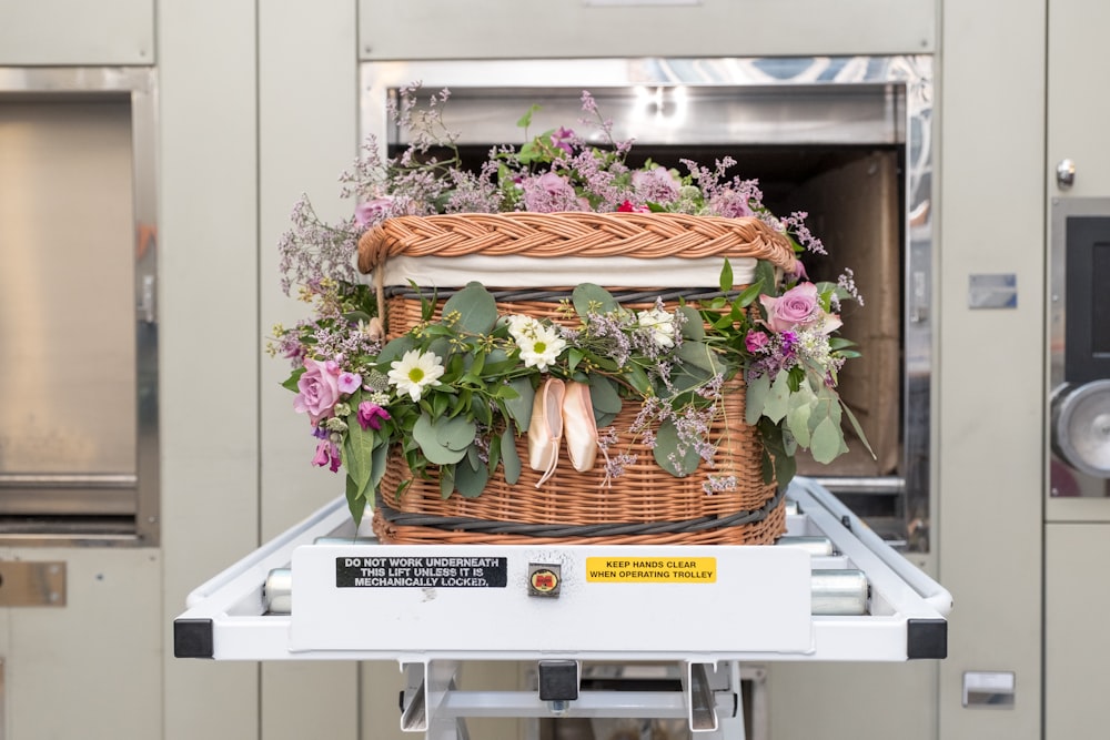 a basket filled with flowers sitting on top of a conveyor belt