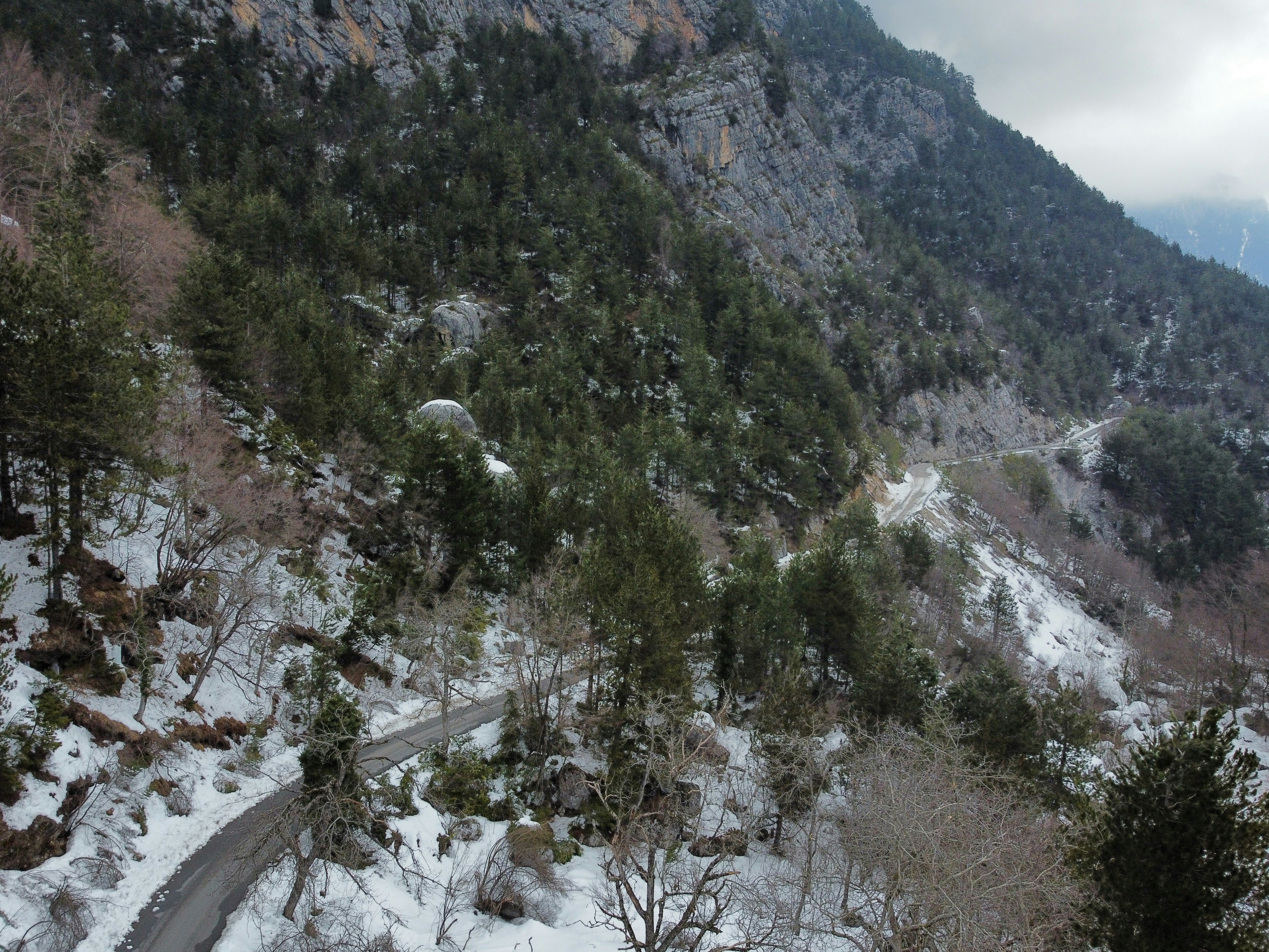 a snowy mountain with a winding road in the foreground