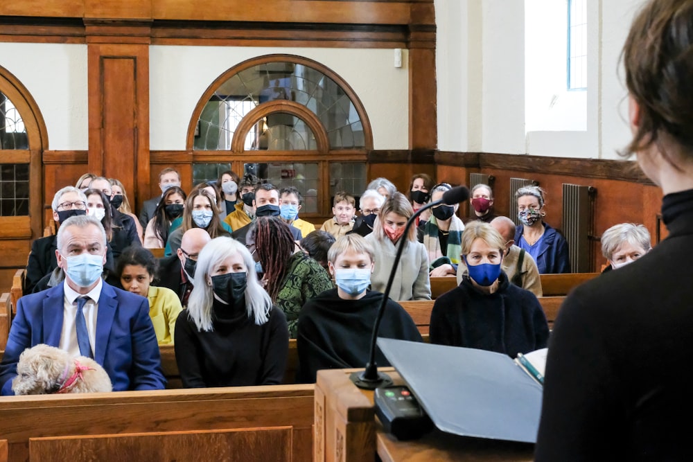a group of people wearing face masks in a courtroom