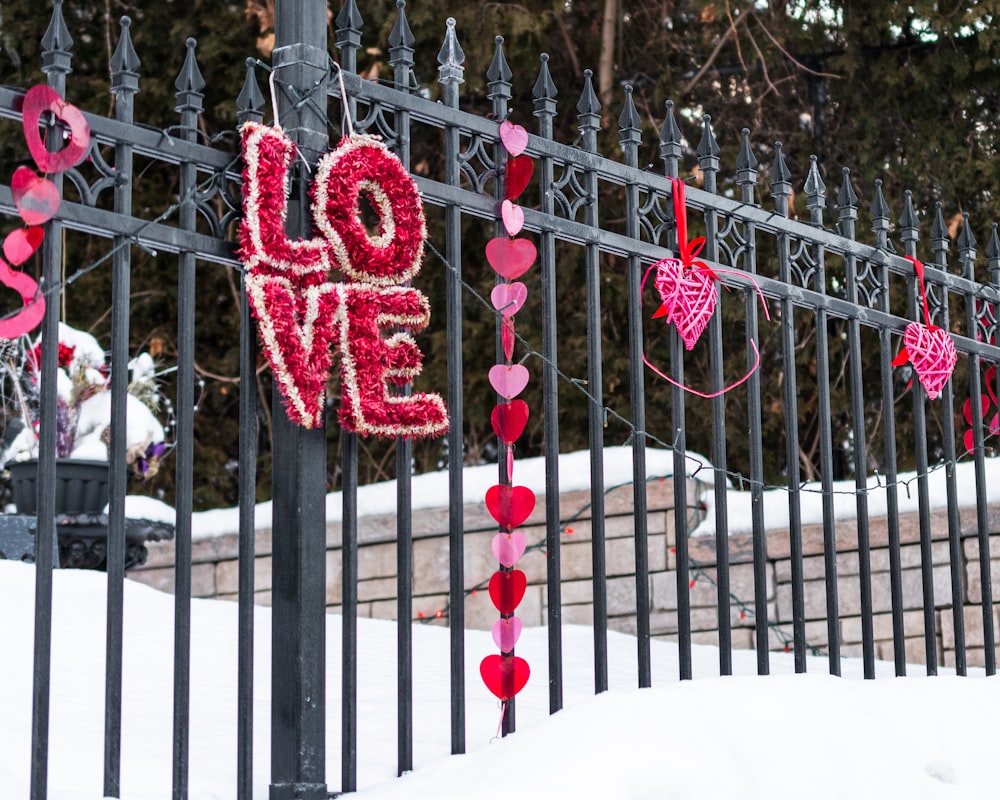 a fence decorated with hearts and a love sign