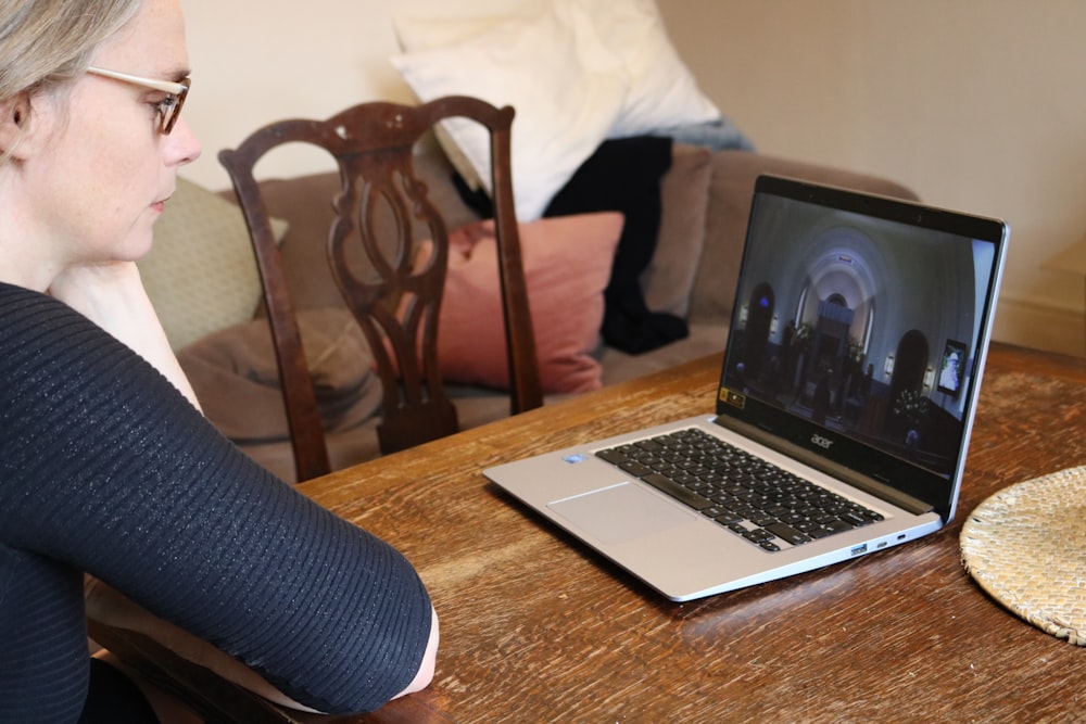 a woman sitting at a table with a laptop