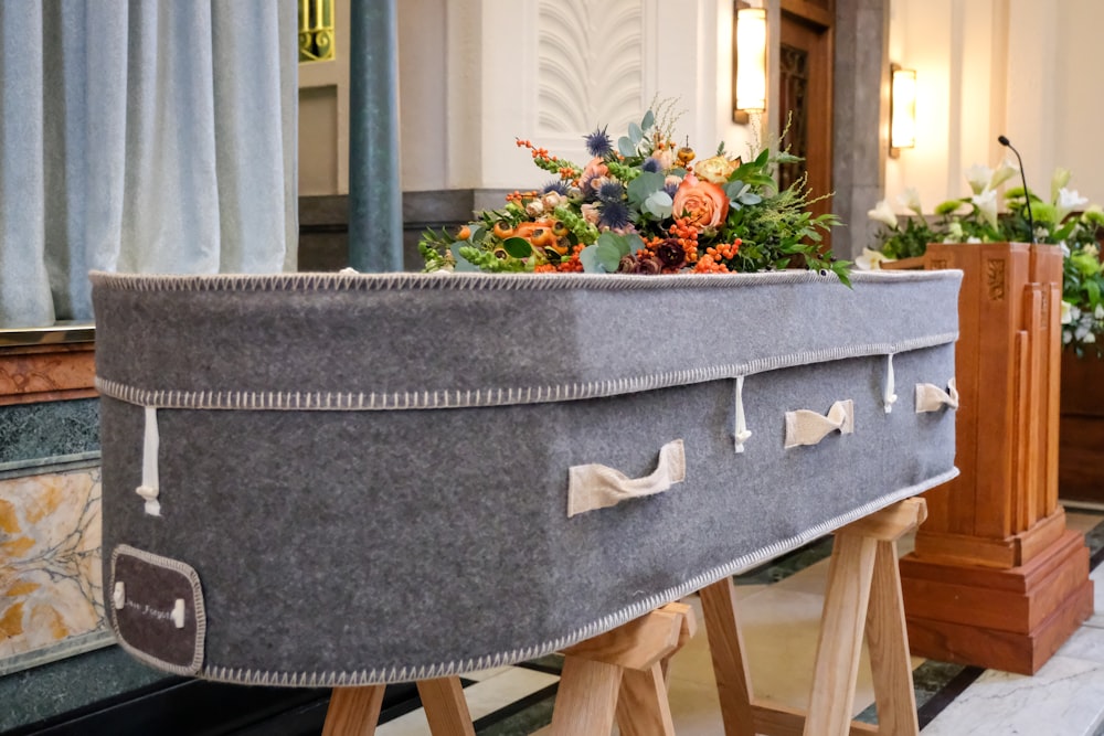 a large gray suitcase sitting on top of a wooden stand