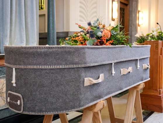 a large gray suitcase sitting on top of a wooden stand