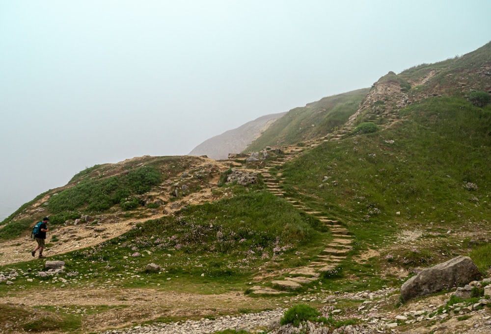 a person walking up a hill with a backpack