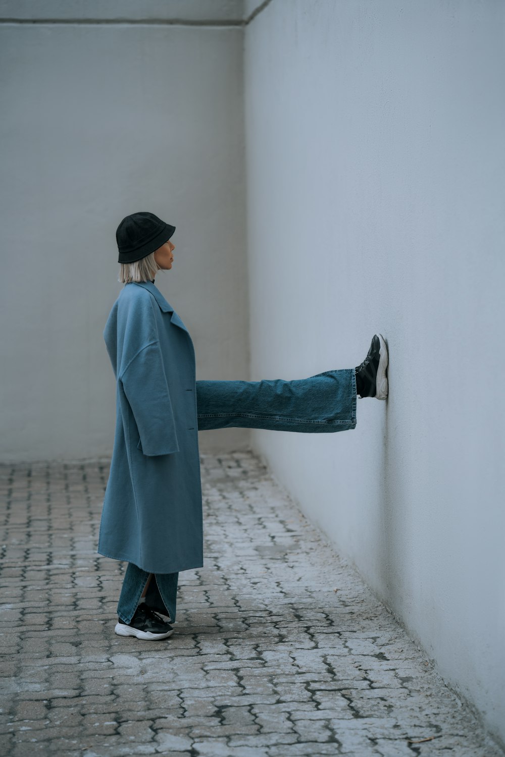 a person leaning against a wall with their foot on a wall