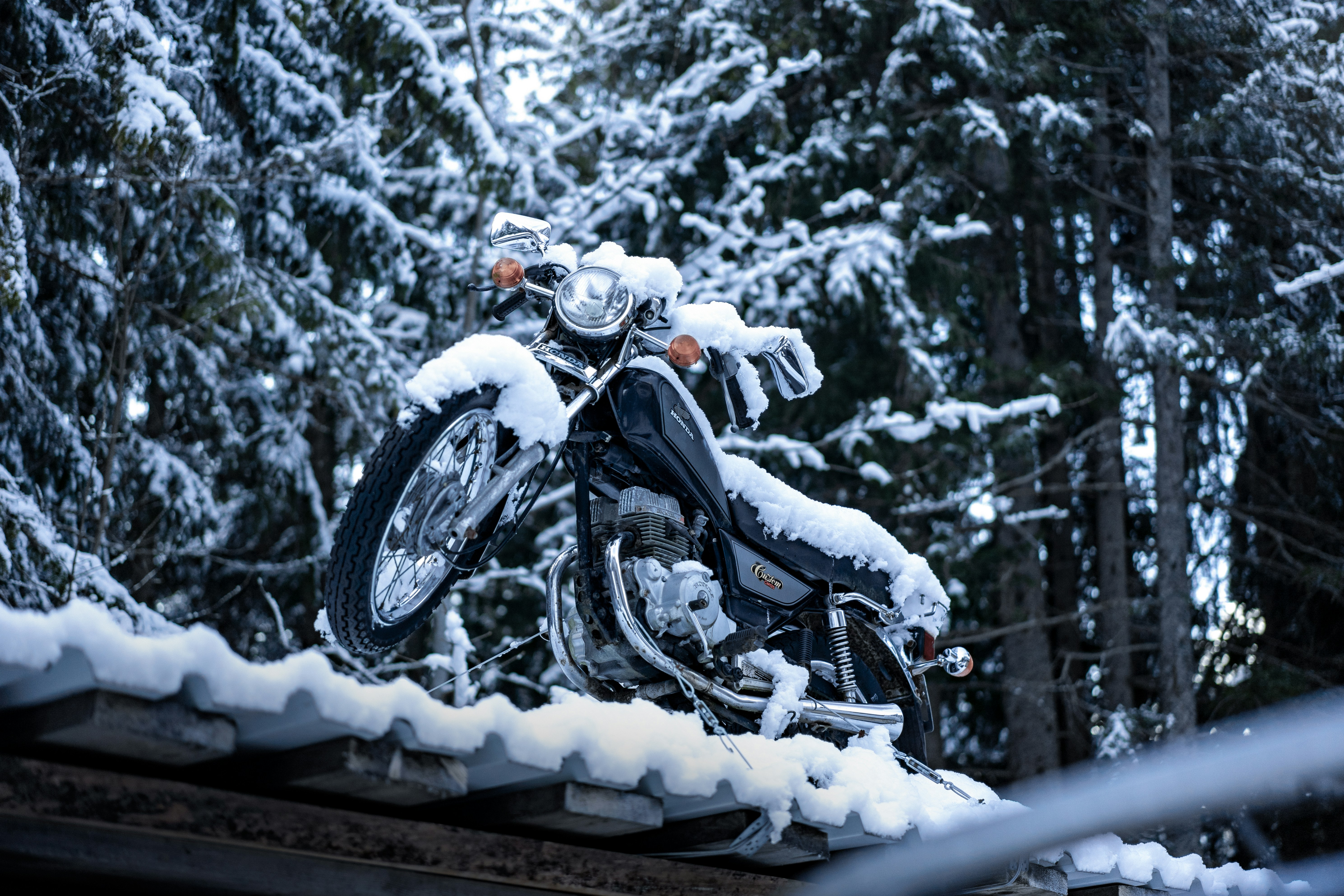A motorcycle parked on top of a roof covered in snow photo Free