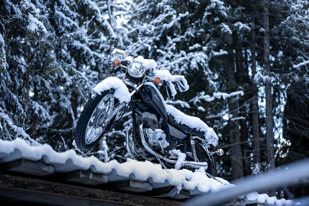 雪に覆われた屋根の上に停めたバイク