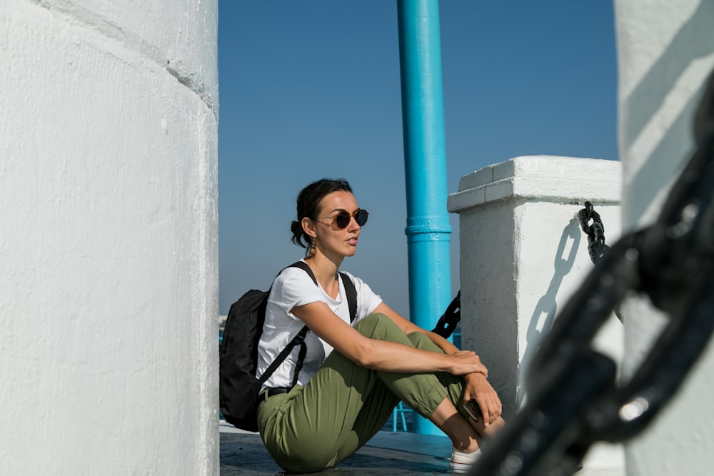 a woman sitting on the ground with a backpack
