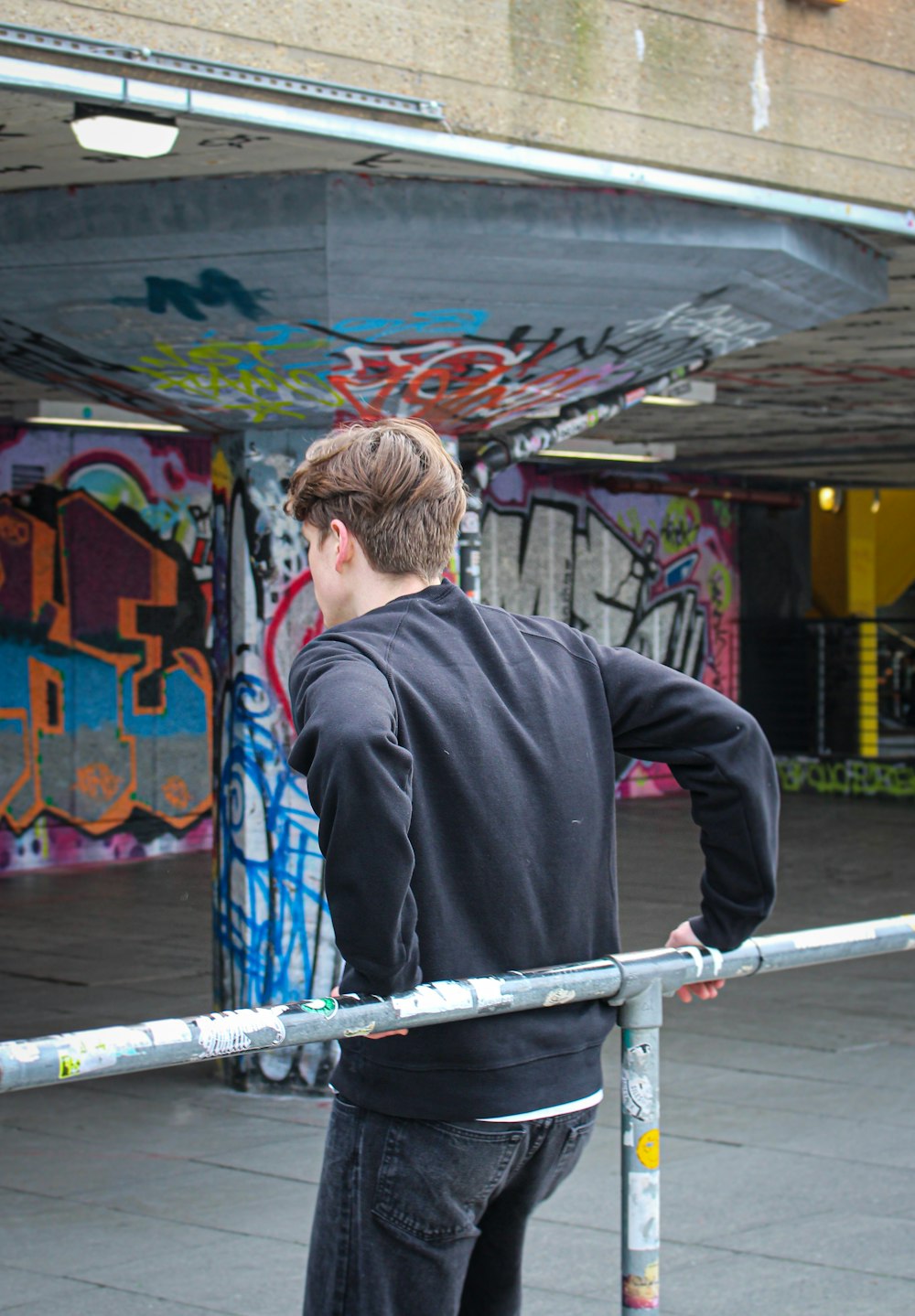 a man standing on a skateboard in front of a graffiti covered building