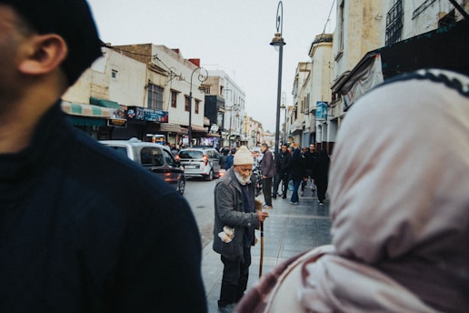 a man is walking down the street with a cane