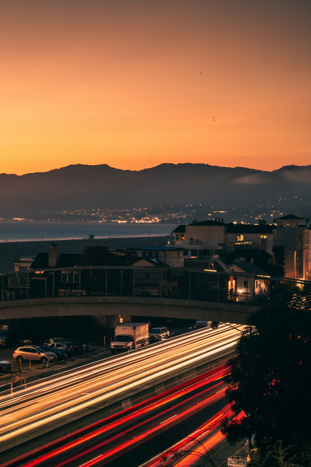 a view of a city with a bridge and mountains in the background