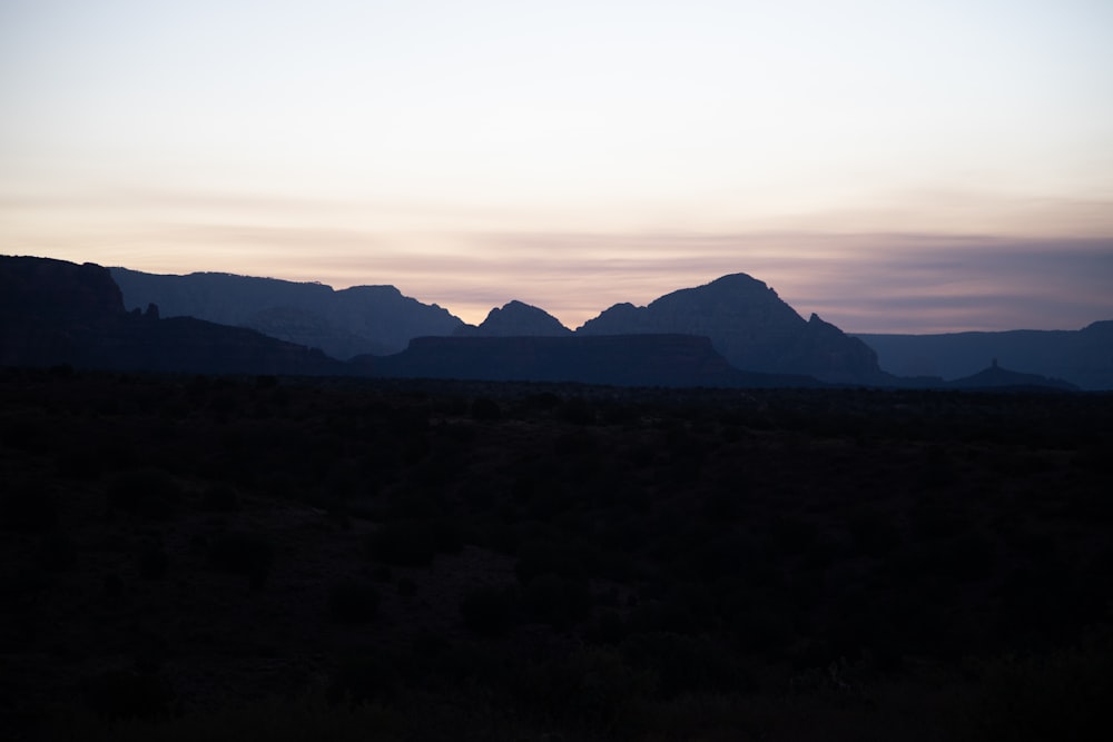 the sun is setting over the mountains in the desert