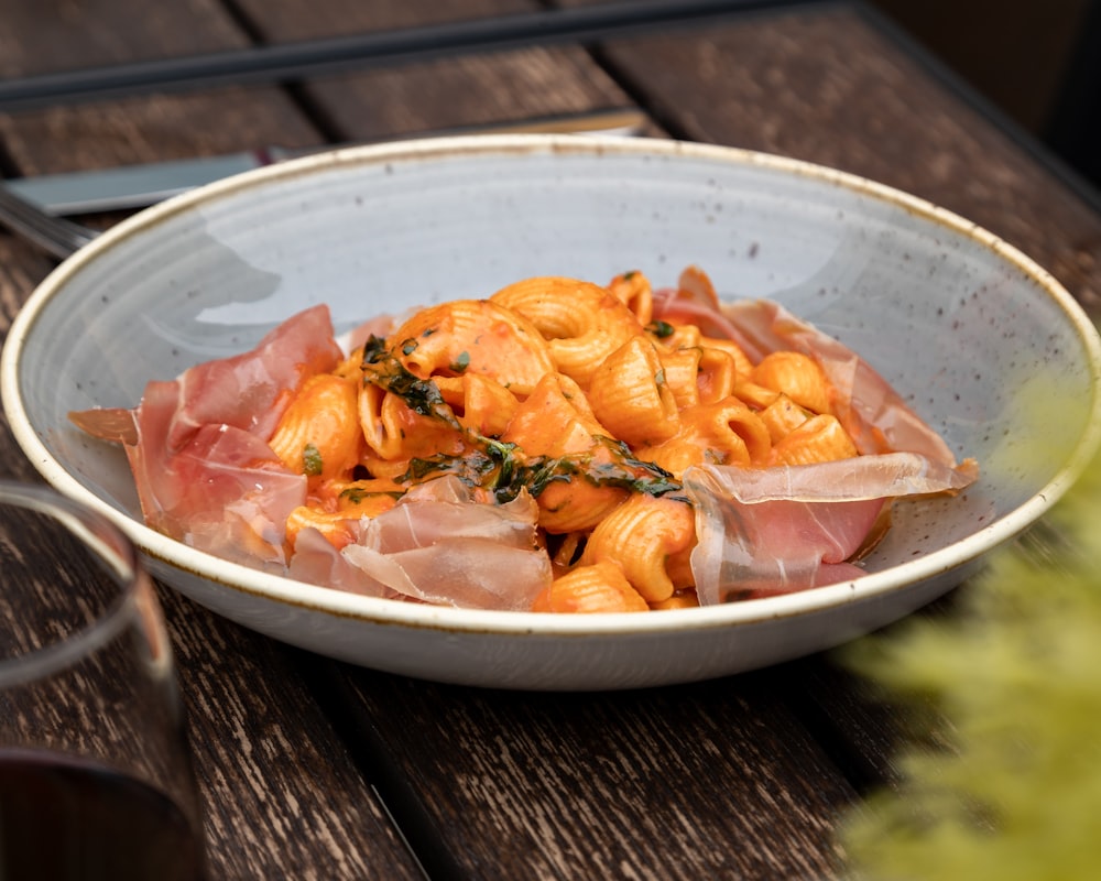 a bowl of pasta with ham and cheese