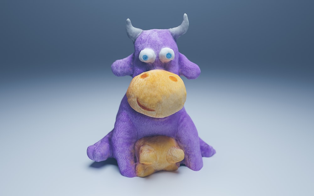 a purple stuffed animal with horns sitting on a table