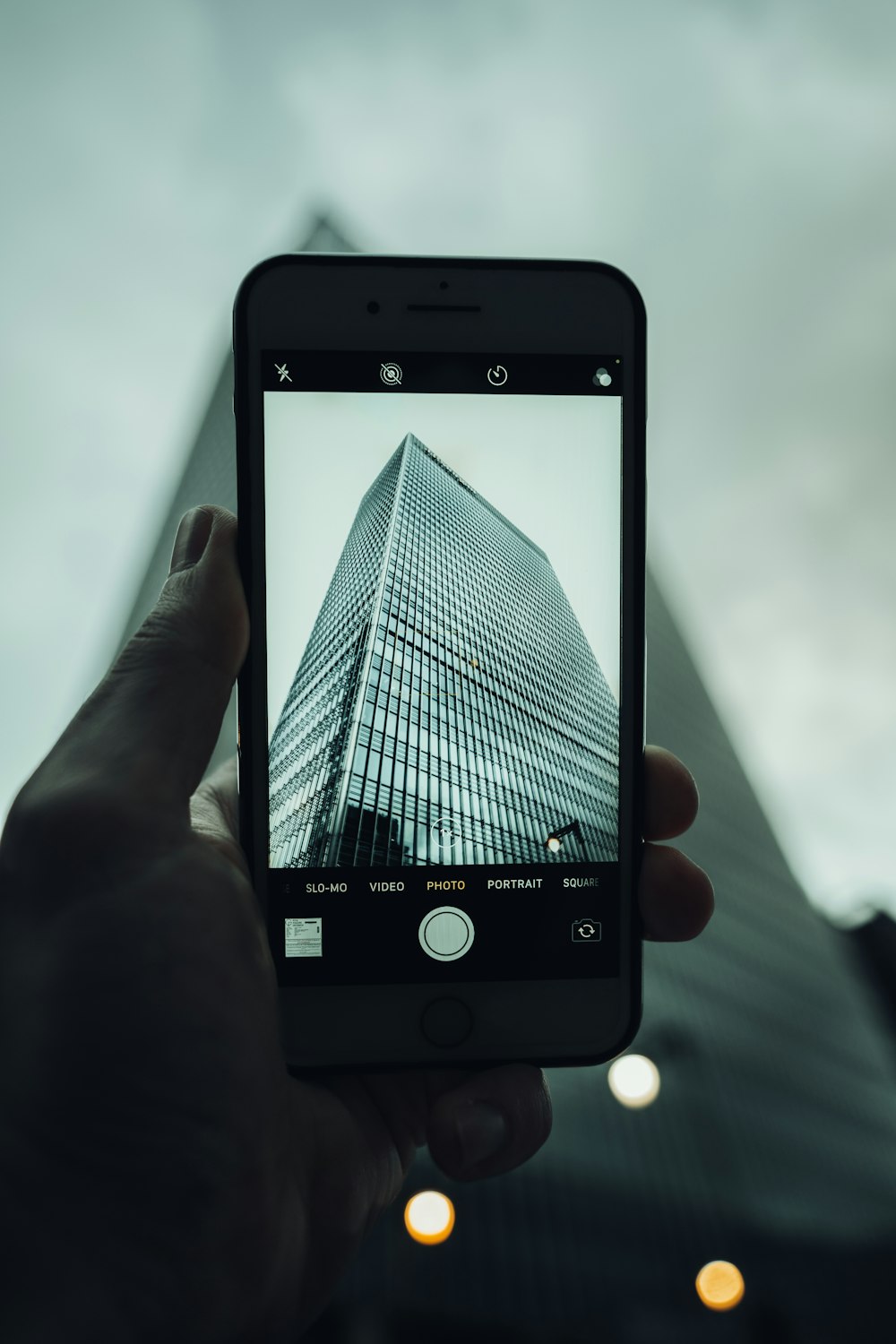 Una persona tomando una foto de un edificio alto