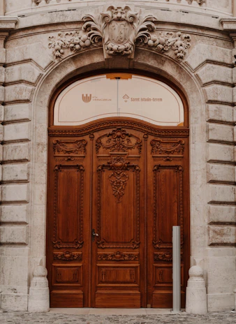 Victorian-style carved wooden door of the Coin Harvey House mansion, detailed with intricate ironwork.