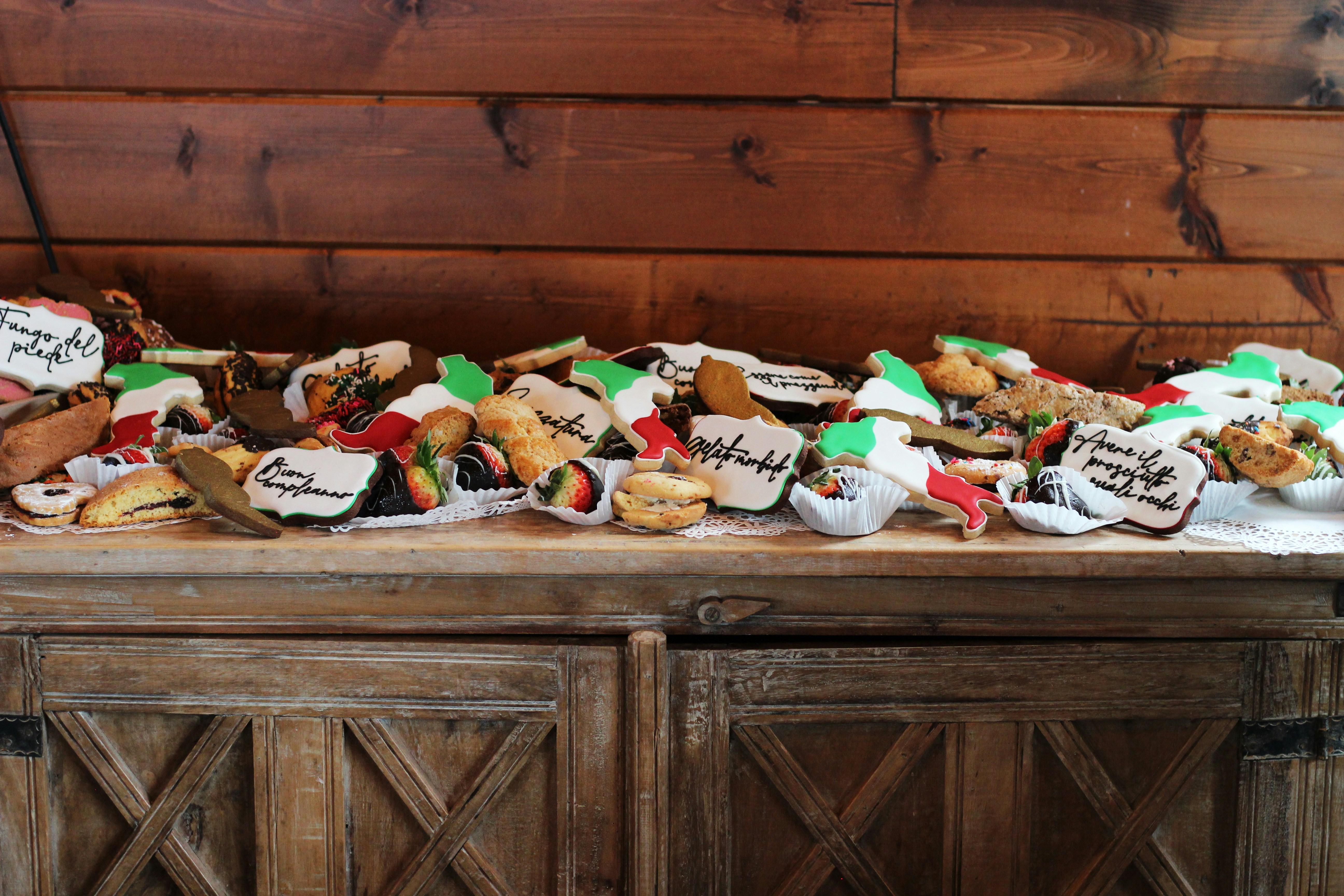 a table topped with lots of cookies covered in frosting