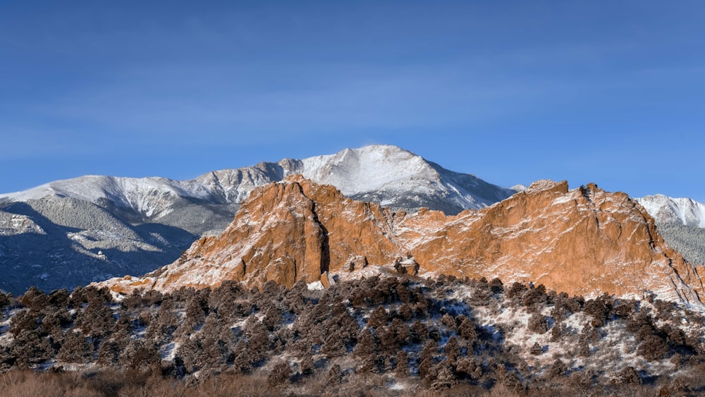 a mountain range covered in snow under a blue sky