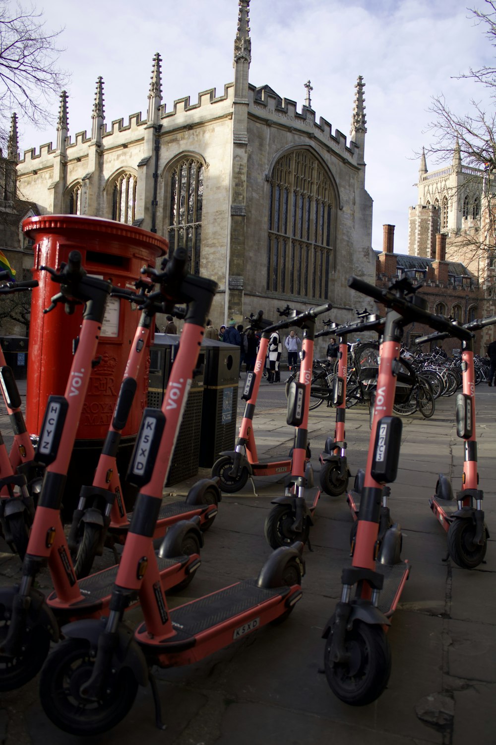 a group of red scooters parked in front of a building