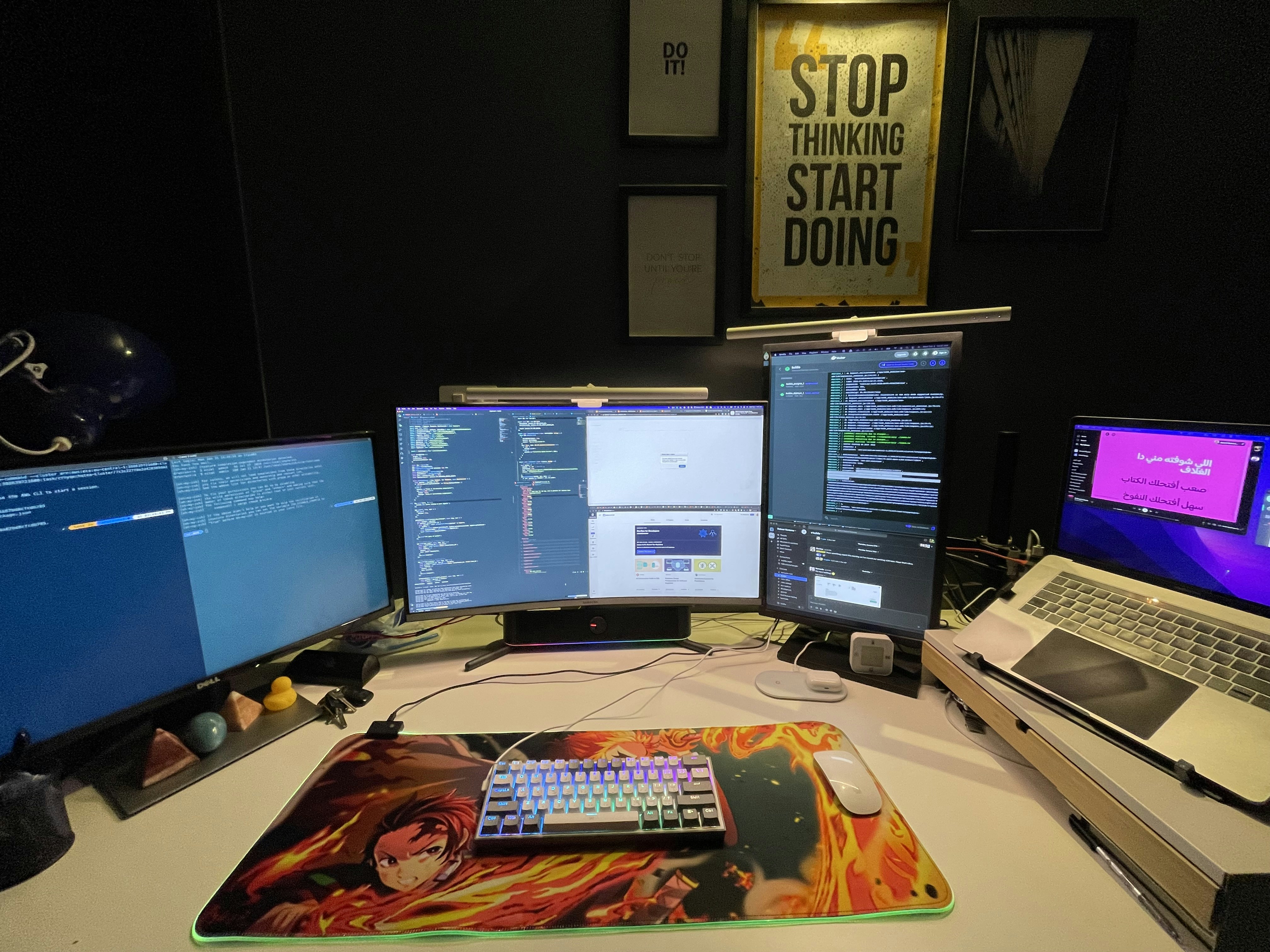 Desk with three computers and a laptop