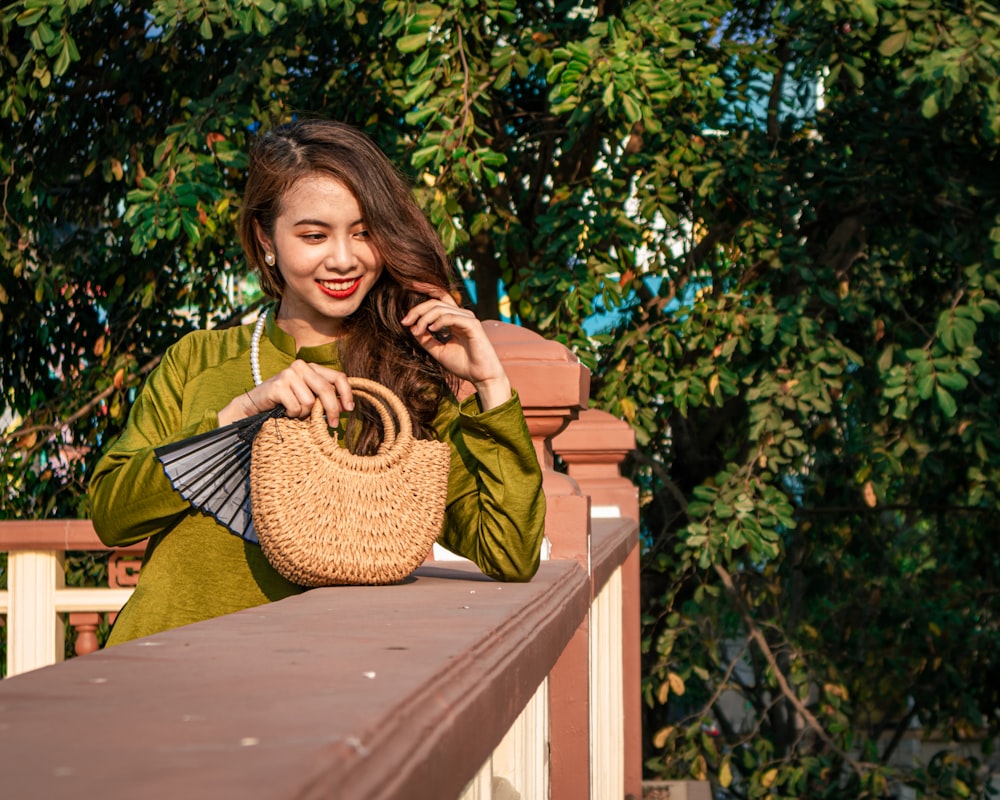 a woman holding a wicker basket on a balcony