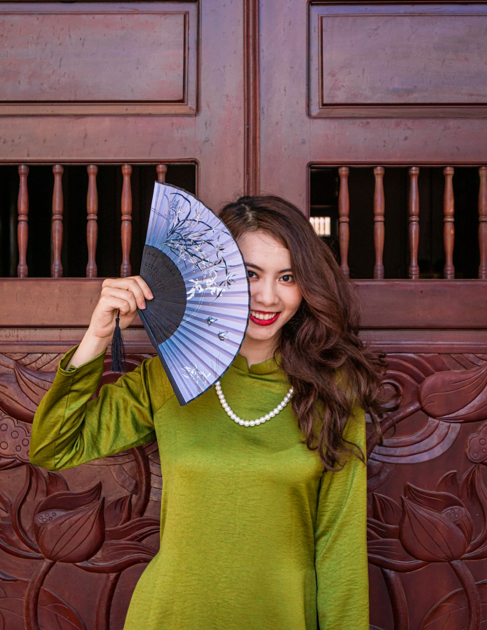 a woman in a green dress holding a blue umbrella