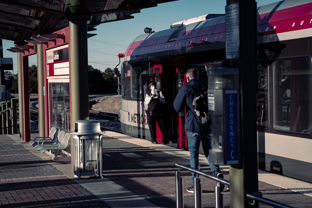 a man standing next to a train at a train station