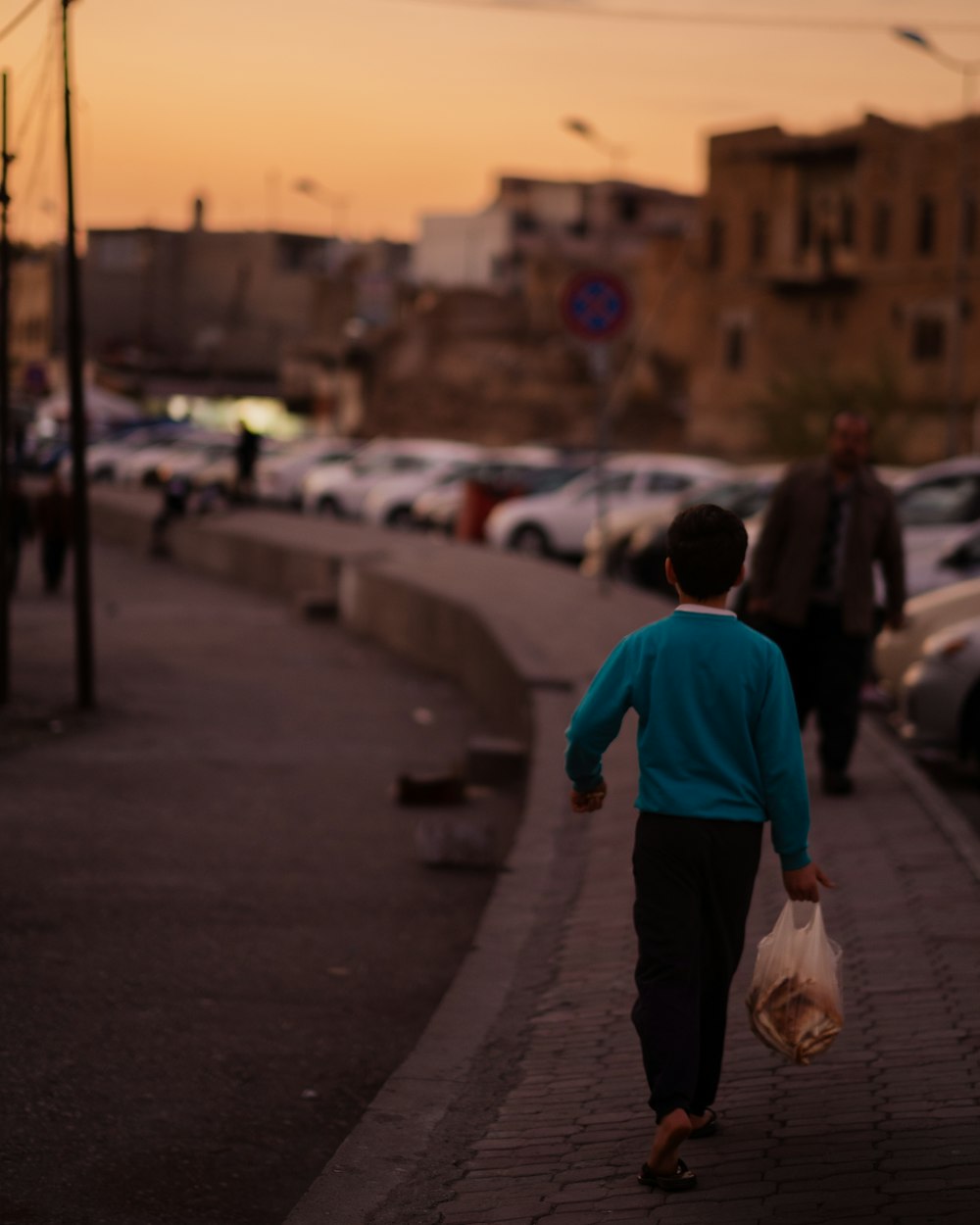 a person walking down a sidewalk with a bag