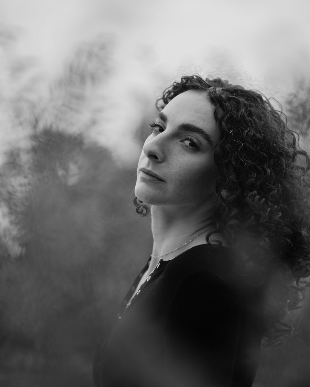 a black and white photo of a woman with curly hair