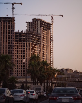a large building with a crane in the background