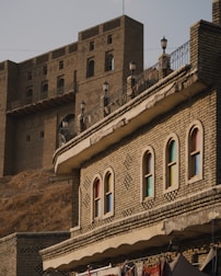 a brick building with a balcony and several windows