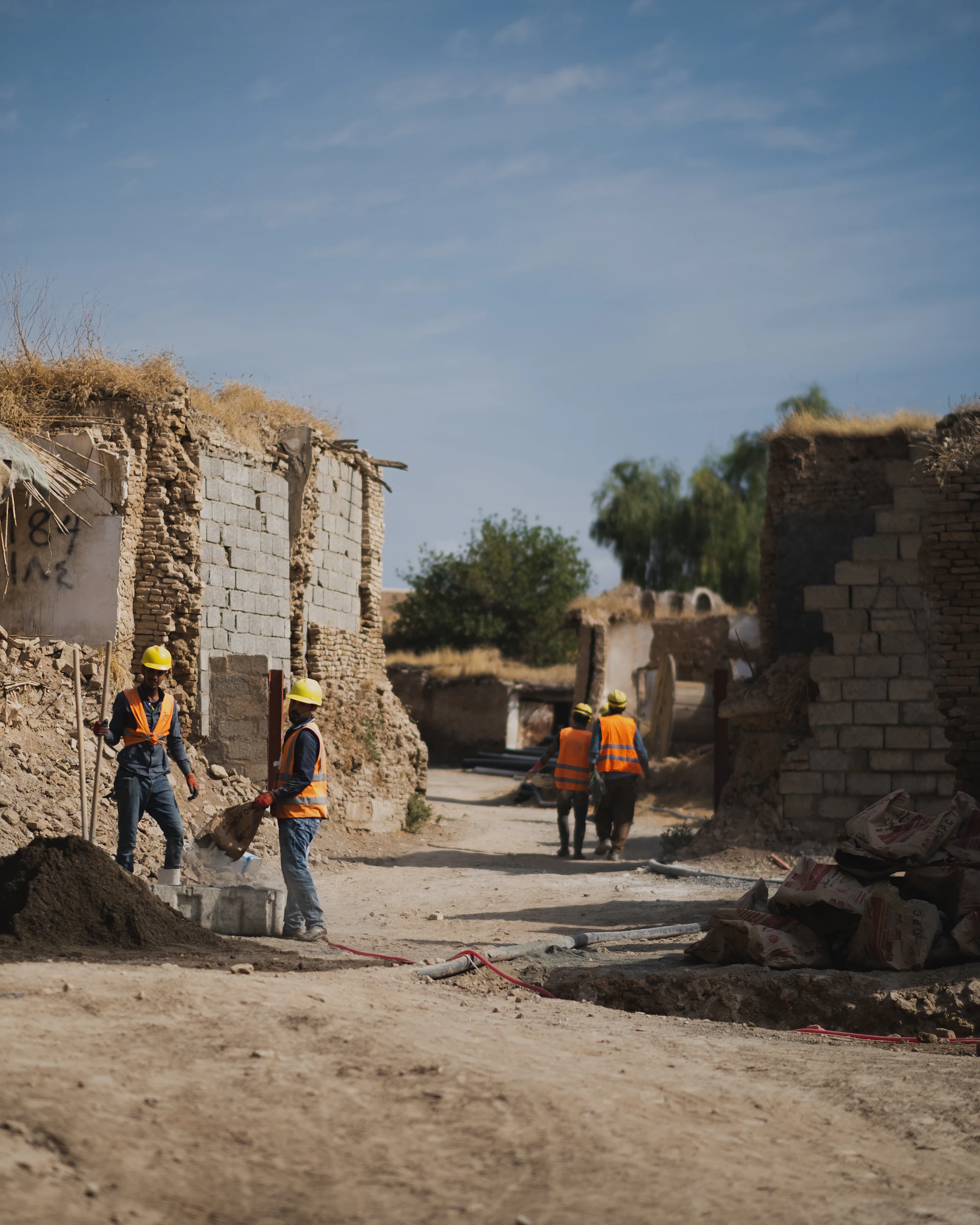 a group of men standing next to a pile of dirt