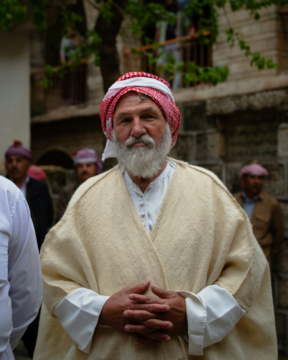 a man with a white beard wearing a red and white turban