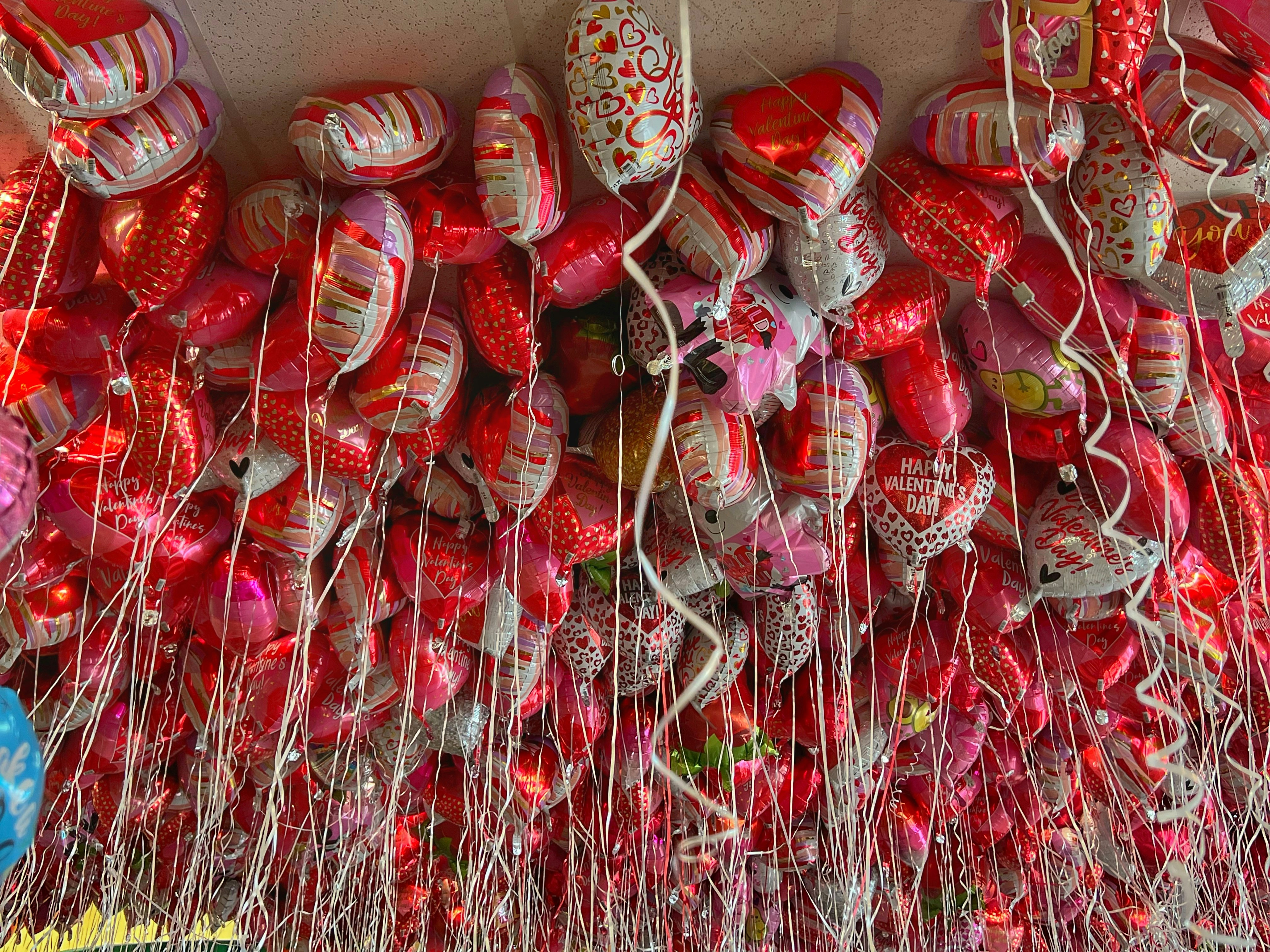 a bunch of red and white shoes hanging on a wall