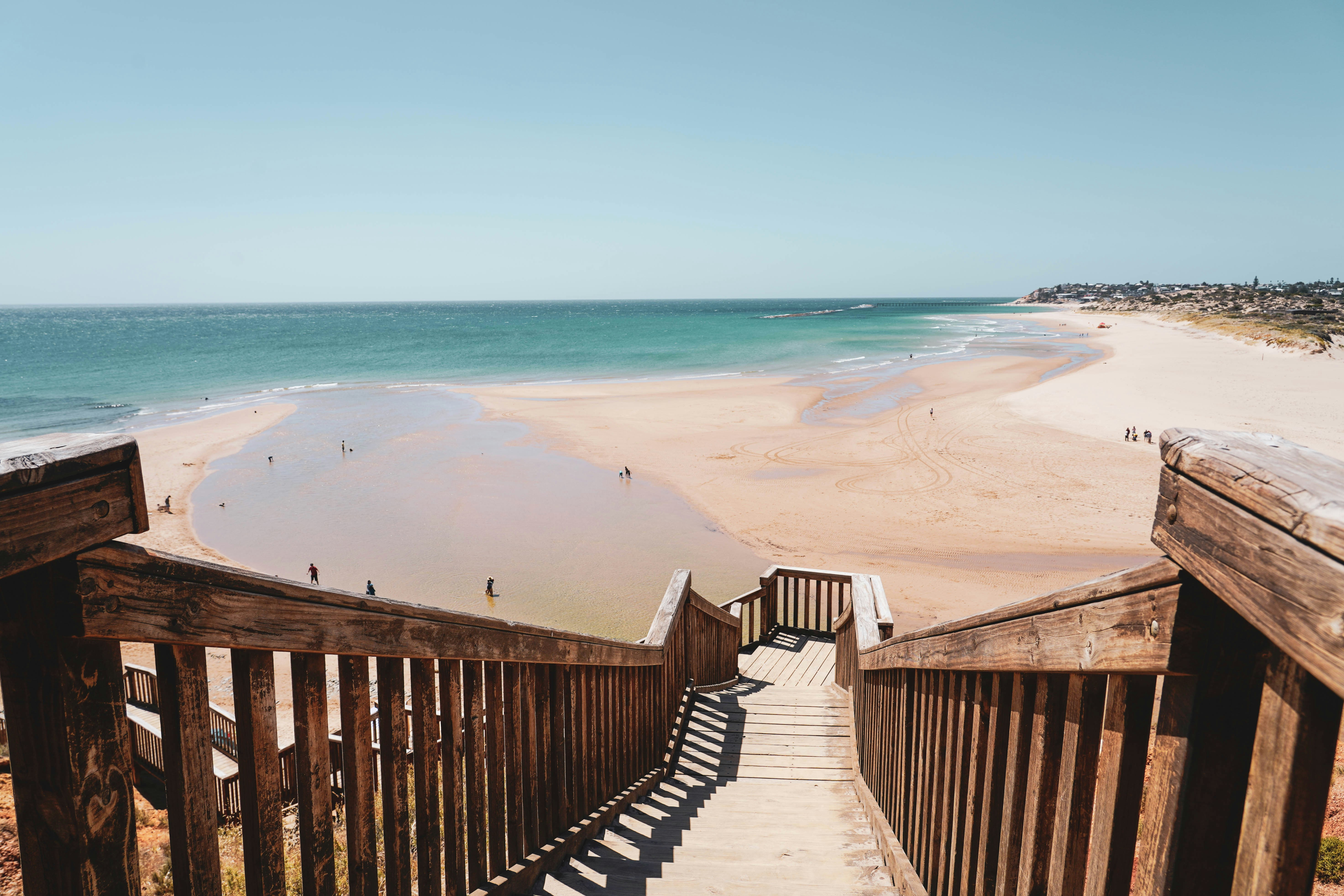 a stairway leading to the beach with people on it, 