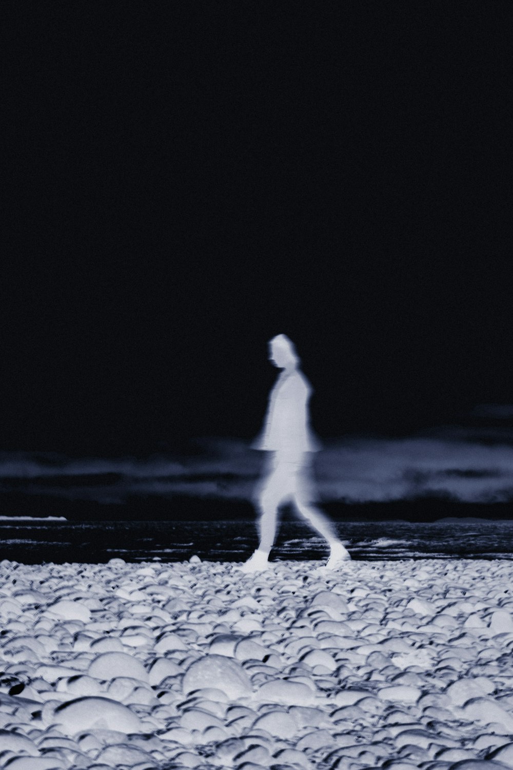 a person walking on a beach at night