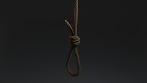 A tightly knotted rope hangs vertically against a dark, shadowy background. The rope's fibers are clearly visible, emphasizing its rough texture.