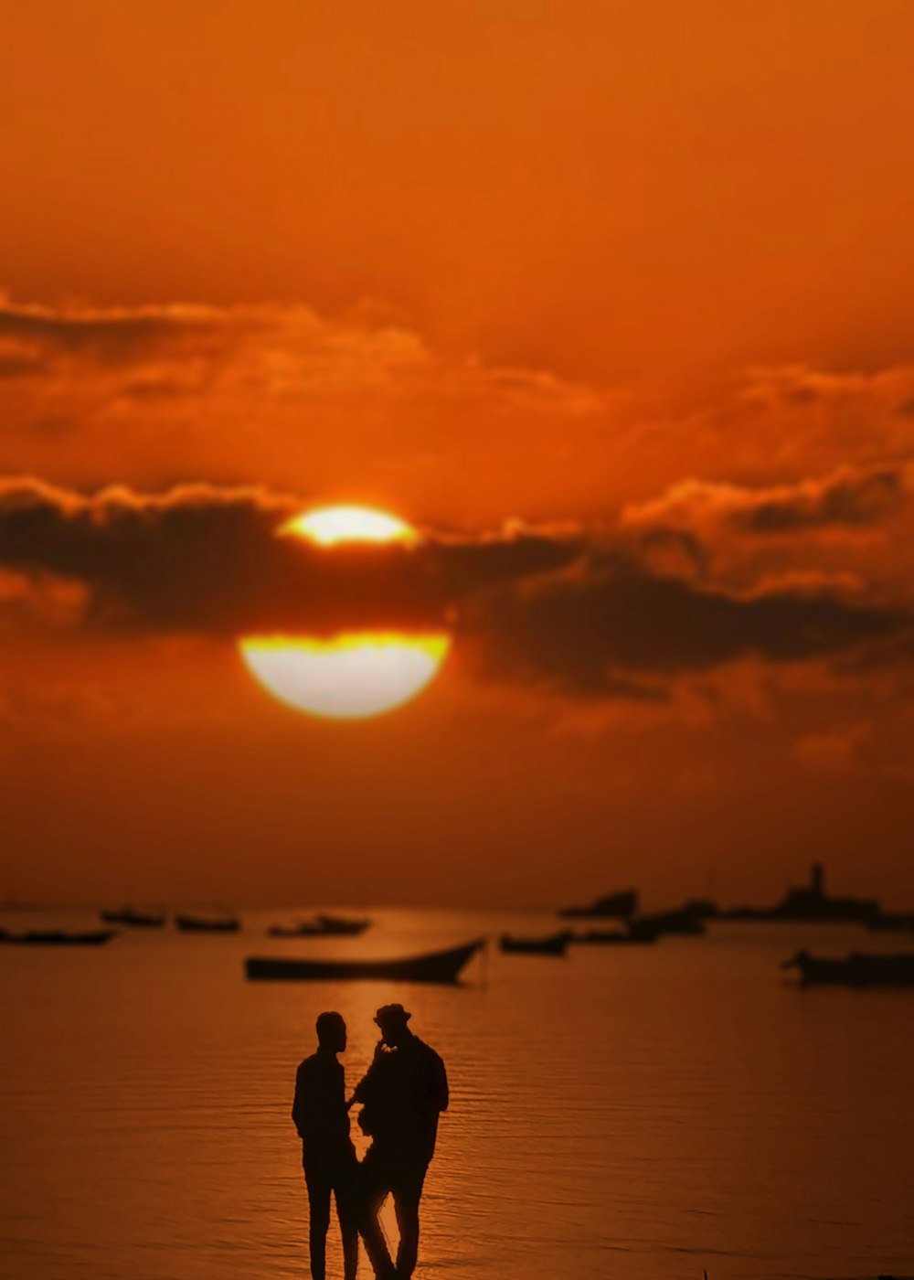 a couple of people standing on top of a beach