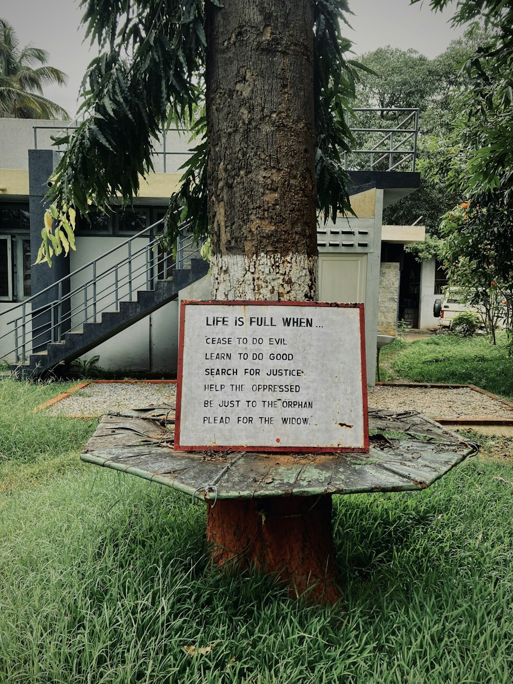 a sign on a tree in a park
