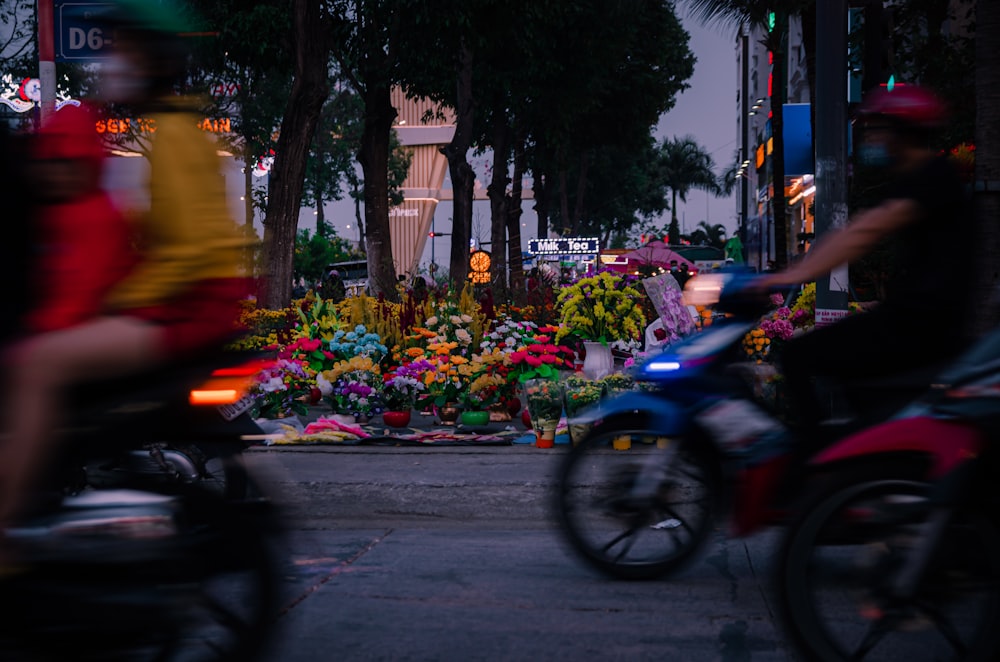 a couple of people riding motorcycles down a street