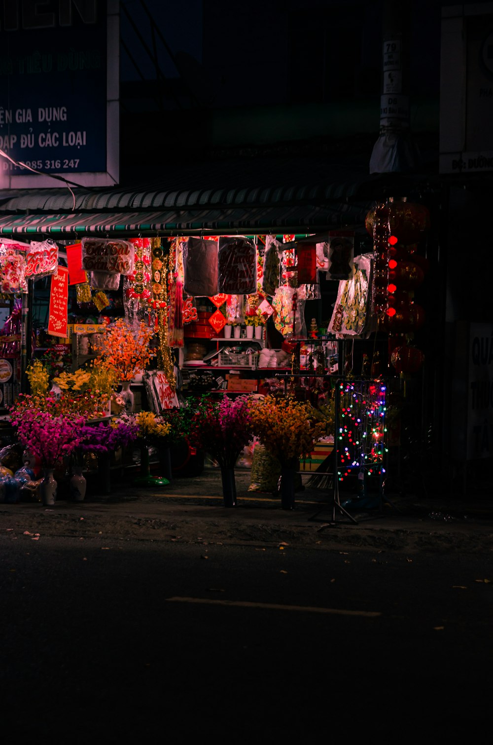 a dark street with a bunch of flowers on display
