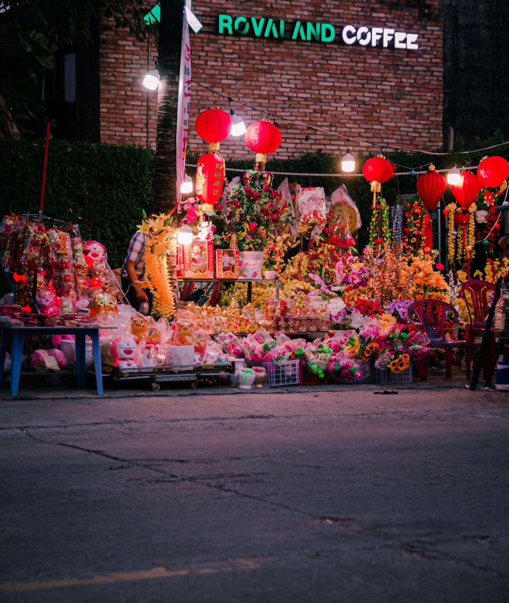 a bunch of flowers and lanterns on the side of the road