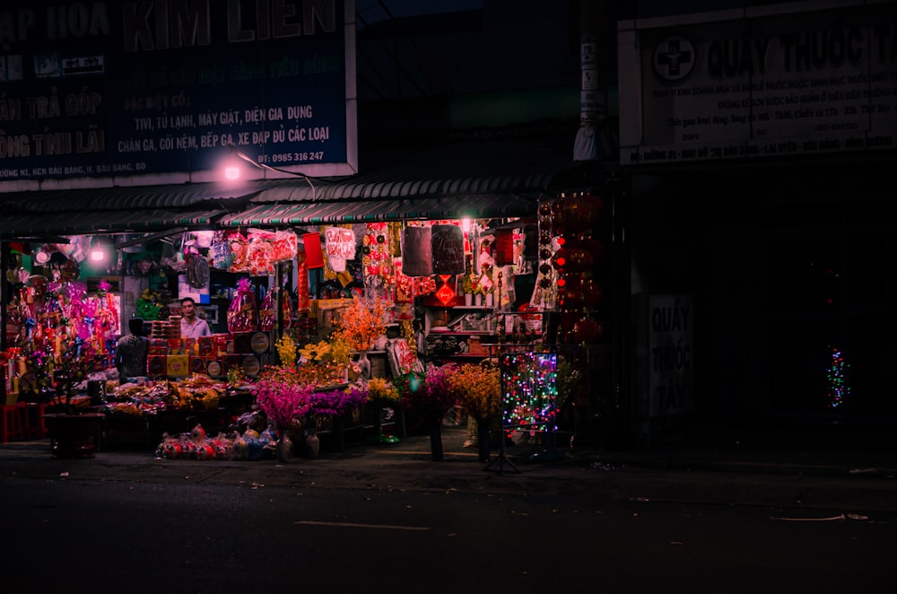 a dark street with a bunch of flowers on display